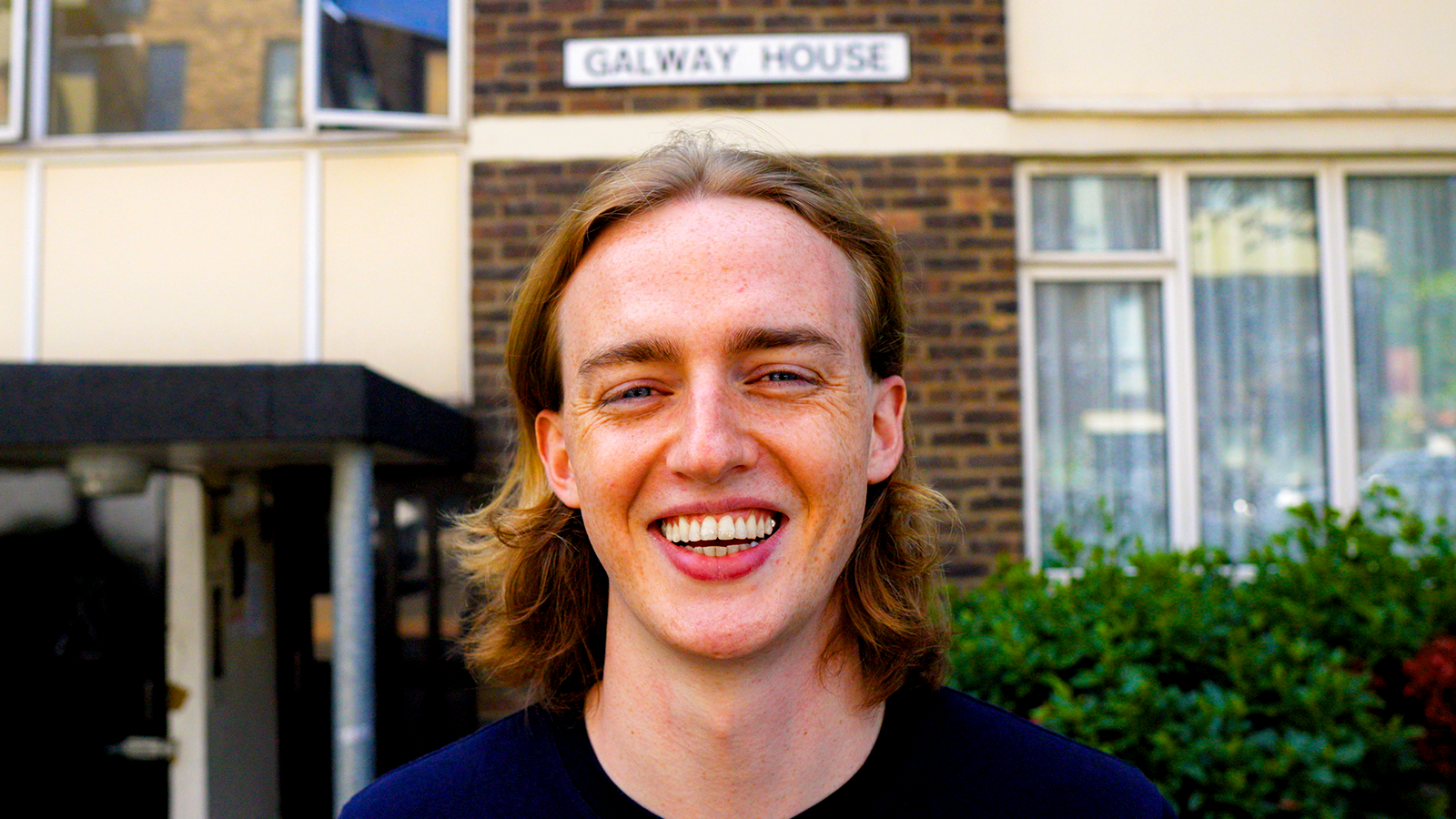Hugo Harvey smiling outside Galway House in east London